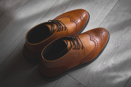Elegant brown dress shoes on wooden floor