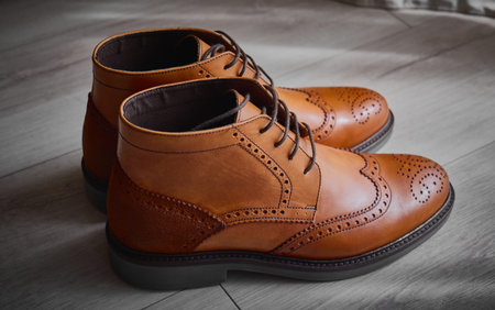 Elegant brown dress shoes on wooden floor