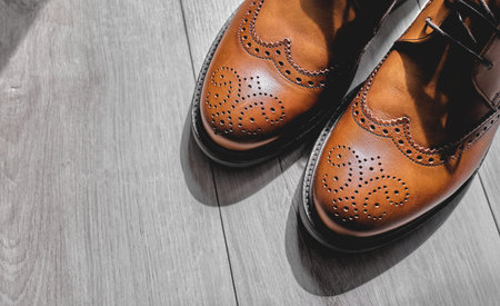 Elegant brown dress shoes on wooden floor