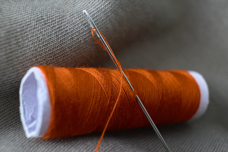 Close up of orange thread and sewing needleの写真素材