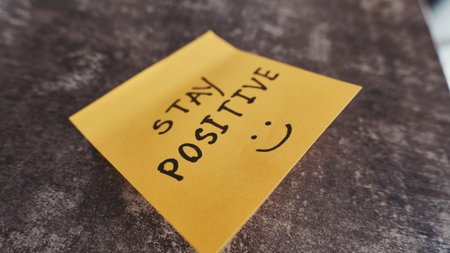 Sticky note with a positive message placed on a surfaceの写真素材