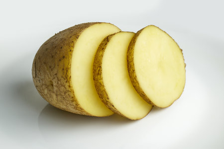 Sliced yellow potato pieces on a clean surface. High quality photoの写真素材