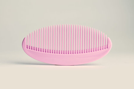 A pink comb rests flat on a smooth surface