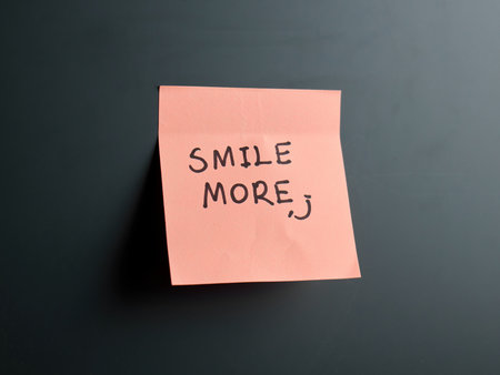 Bright pink sticky note with a motivational quote to smile.の写真素材