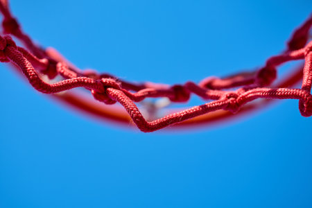 A red basketball net outlined against a clear sky.の写真素材