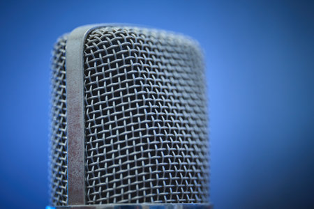 A detailed view of a microphone with a blue backdrop.の写真素材