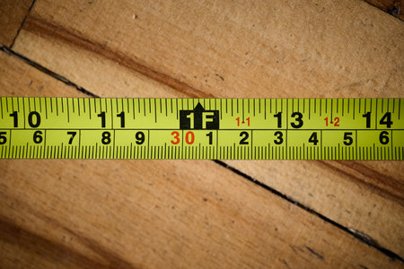 Bright measuring tape is placed on wooden flooring.の写真素材