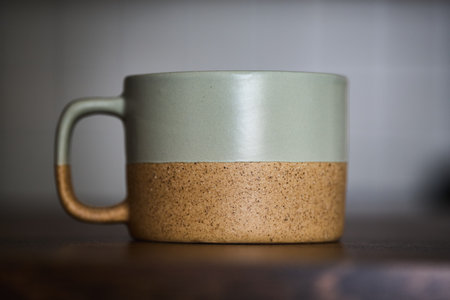Ceramic cup sits on a wooden surface in a great position.の写真素材