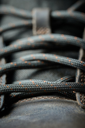 The shoelaces are tightly laced on a brown shoe surfaceの写真素材