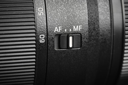 A focus adjustment switch on a camera lens is shown.