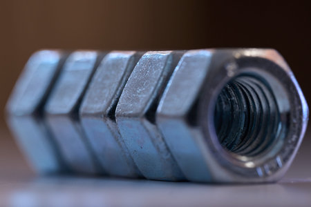 Detailed close up of chrome plated internal thread fasteners with shallow depth of field