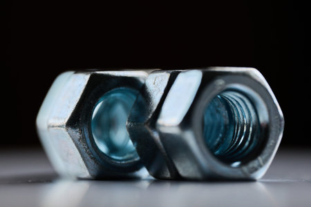 Detailed close up of chrome plated internal thread fasteners with shallow depth of field