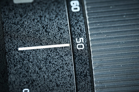 Detailed view of the focus ring and focal length markers on a professional black camera lens barrel