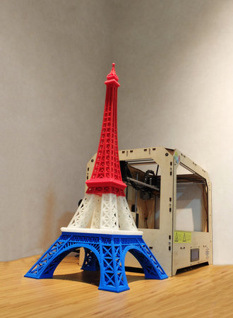 Eiffel Tower Model with Red White Blue Stripe printed by 3D Printer with 3D Printer on Wooden Table