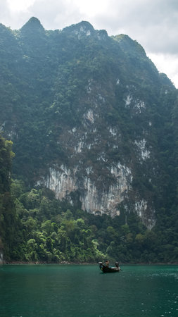 Scenic View of Traveler in Small Boat Sightseeing Beautiful Ratchaprapa dam , Khao sok national park...