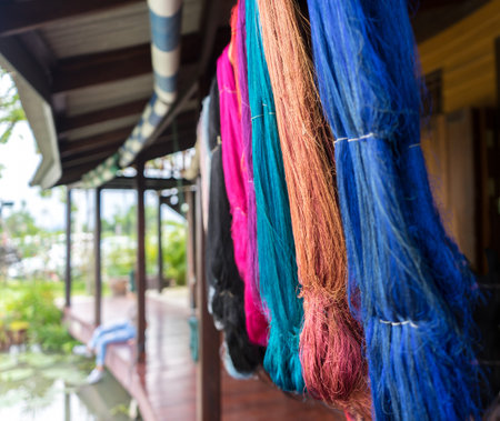 Various Colorful Dyeing Silks such as Blue, Brown, Pink Hanging from The Roof in Pattern after Thai...