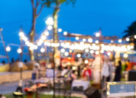 Blur Night Market with Bokeh of Lights from Many Shops in The Evening with Clear Dark Blue Sky by The Sea at Hua Hin, Thailandの写真素材