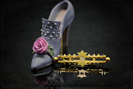 An heirloom gold broach set with a small center diamond, popular in the art deco era, placed beside...