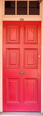 Old red timber door in a city street in Australia