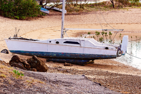 Boat moored on a sandy beach with tide outのeditorial素材