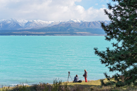 LAKE PUKAKI, NEW ZEALAND - April 2018: The snow covered alpine mountains across the beautiful blue waters of Lake Pukaki on the south island of New Zealand attract thousands of photography enthusiasts each year. The topaz blue water is caused by melting gのeditorial素材