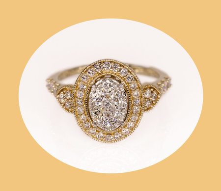 Ornate yellow gold and white diamond halo style ring reminiscent of a bygone era of fashion on a...