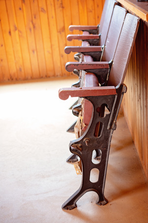 Row of vintage fold up chairs against a timber wallの写真素材