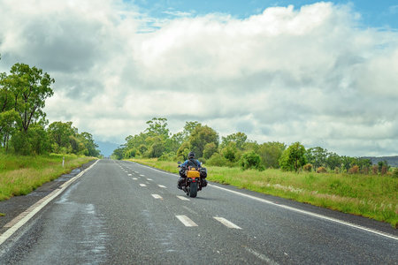 Road Trip - A motor cyclist overtaking on a long stretch of highwayの写真素材
