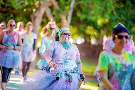 MACKAY, QUEENSLAND, AUSTRALIA - JUNE 2019: Unidentified woman smiles as she walks in Color Frenzy Fun Runのeditorial素材