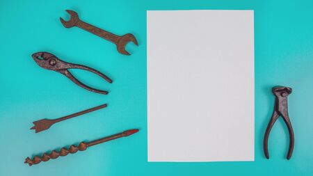 Old work tools and white blank paper on blue green background for message fathers day overhead top view flatlay with copy spaceの写真素材