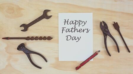 Old work tools and Happy Fathers Day card message on timber background overhead top view flatlayの写真素材