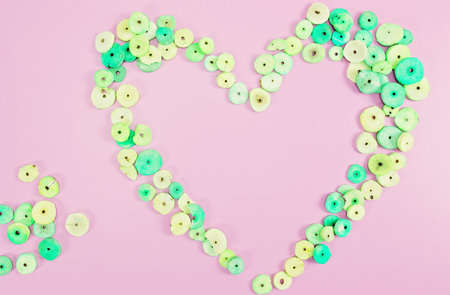 Lemongrass scented buttons shaped into a heart on a pink background with text copy space
