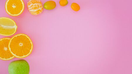 Fresh tropical citrus fruits on pink background message card with copy space for textの写真素材