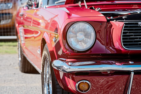 MACKAY, QUEENSLAND, AUSTRALIA - 13th July 2019: Close up of the front headlight and bumper of red...