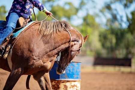 Close up of competitor on horseback making a figure eight turn in a barrel race at outback country rodeoの写真素材