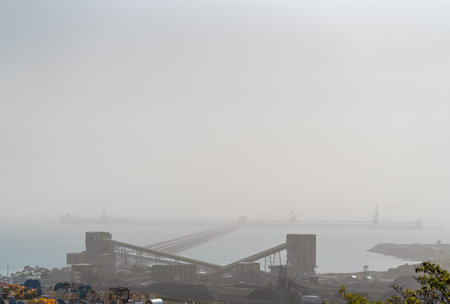An Australian export coal loading terminal on a hazy day polluted by intense bush fire smoke