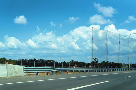 Highway guard rail and high wire netting to prevent flying debris on a busy main arterial highway