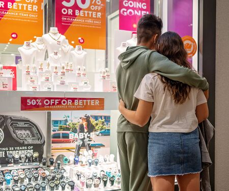 Brisbane, Queensland, Australia - October 2019: A young couple embrace as they look at jewelry in a shopping centre storeのeditorial素材
