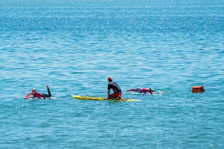Mackay, Queensland, Australia - October 2019: Nippers learning to paddle on their boards in the ocean under the supervision of a lifeguard at Harbour Beachのeditorial素材