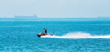 Mackay, Queensland, Australia - October 2019: A jet ski rider speeding across the ocean on the way...