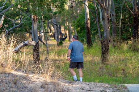 Mackay, Queensland, Australia - October 2019: An overweight man walking in bushland for exercise to lead to a healthier lifestyleのeditorial素材