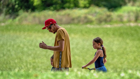 Mackay, Queensland, Australia: 3rd November 2019: Father and his two daughters walking outdoors in...