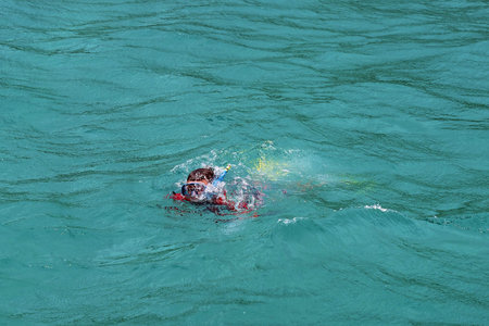 Small boy in the water all geared up, gets used to his breathing apparatus and be ready to go...