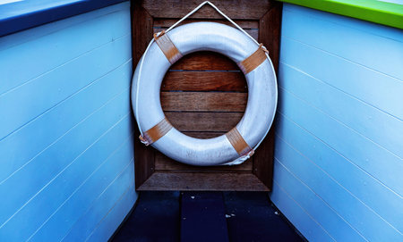 A white plastic lifebuoy on a ship deck for personal marine safety