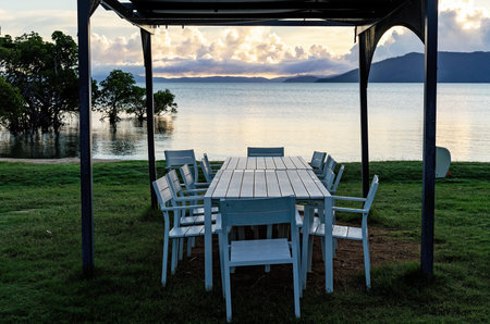 Outdoor table setting under shade by the sea at a casual coastal resort restaurant
