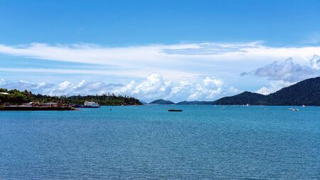Barges docked at harbour ready to deliver goods to islands, construction work nearby, yachts on waterの写真素材
