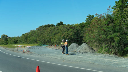 Mackay, Queensland, Australia - June 2020: Two workers standing idle talking and surveying a pile of...