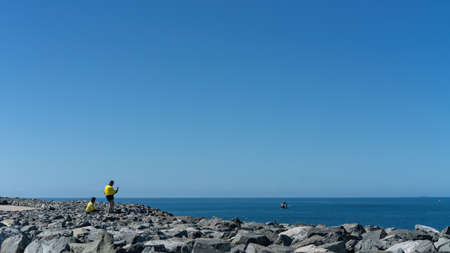 Mackay, Queensland, Australia - June 2020: Workers on lunch break at the harbour taking photos of fishing boat heading out to seeのeditorial素材