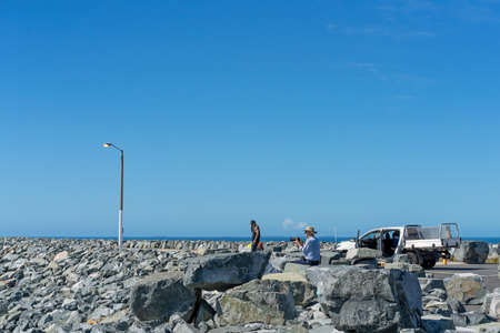 Mackay, Queensland, Australia - June 2020: Men enjoying the atmosphere of the breakwater at Mackay harbourのeditorial素材