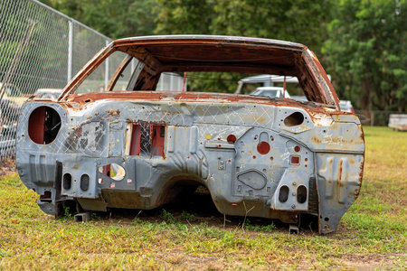 Part of the rusted frame of a classic car which was undergoing restoration but is now abandoned